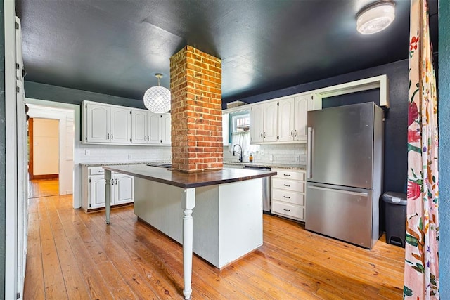 811 S Barker Ave, El Reno, OK 73036 - kitchen with appliances with stainless steel finishes, light wood-style flooring, and backsplash