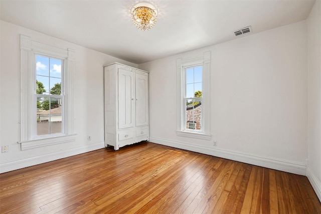 811 S Barker Ave, El Reno, OK 73036 - unfurnished bedroom featuring multiple windows and light wood-style floors