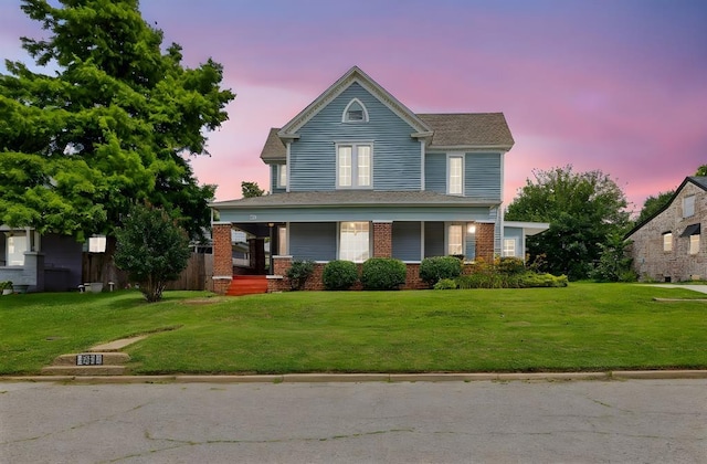 811 S Barker Ave, El Reno, OK 73036 - view of front facade featuring a porch, a front yard, and brick siding