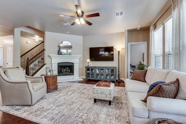 637 Branch Line Rd, Yukon, OK 73099 - living area featuring a ceiling fan, wood finished floors, a fireplace with raised hearth, and stairs
