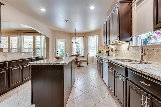 637 Branch Line Rd, Yukon, OK 73099 - kitchen featuring a center island, dishwasher, decorative backsplash, light stone counters, and light tile patterned floors