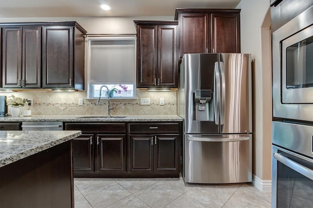637 Branch Line Rd, Yukon, OK 73099 - kitchen with appliances with stainless steel finishes, light stone countertops, light tile patterned floors, decorative backsplash, and recessed lighting