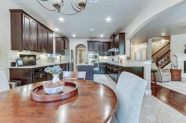 637 Branch Line Rd, Yukon, OK 73099 - dining room featuring arched walkways, a chandelier, light tile patterned floors, and recessed lighting