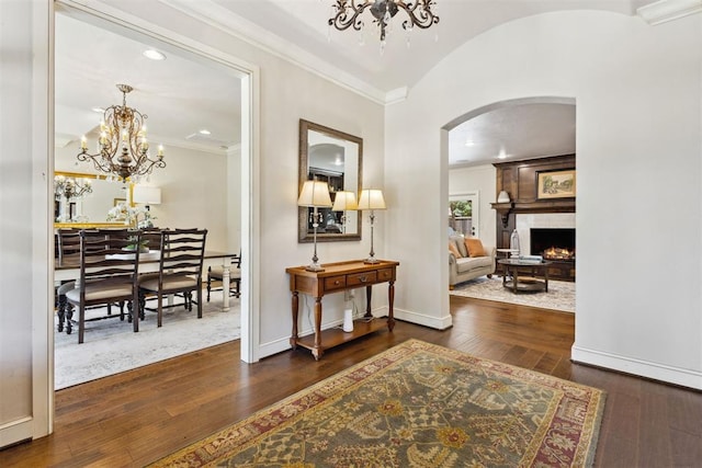 8700 N Waverly Ave, Oklahoma City, OK 73120 - foyer with a chandelier, arched walkways, crown molding, hardwood / wood-style floors, and a large fireplace