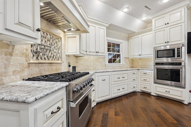 8700 N Waverly Ave, Oklahoma City, OK 73120 - kitchen with appliances with stainless steel finishes, premium range hood, backsplash, white cabinets, and recessed lighting