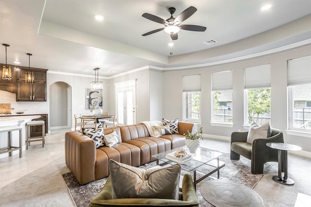 17817 Morning Sky Ct, Edmond, OK 73012 - living area with arched walkways, ceiling fan, recessed lighting, a tray ceiling, and light carpet
