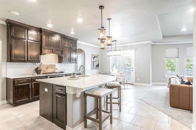 17817 Morning Sky Ct, Edmond, OK 73012 - kitchen featuring plenty of natural light, arched walkways, light countertops, ornamental molding, and backsplash