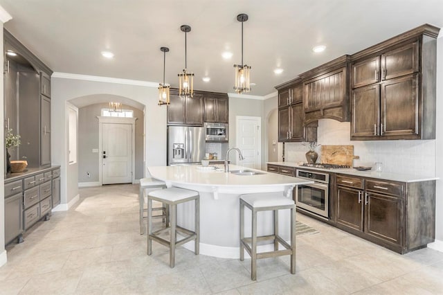 17817 Morning Sky Ct, Edmond, OK 73012 - kitchen featuring appliances with stainless steel finishes, arched walkways, decorative backsplash, a breakfast bar area, and light countertops