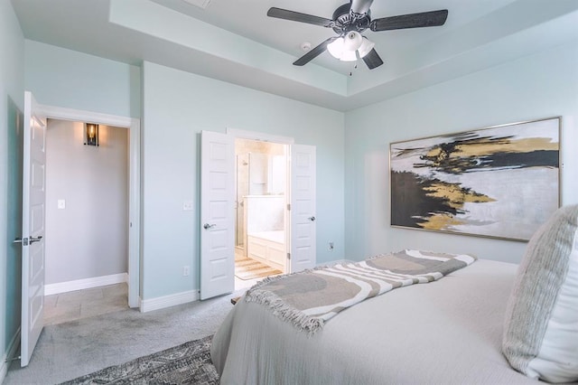 17817 Morning Sky Ct, Edmond, OK 73012 - carpeted bedroom with a tray ceiling, ensuite bath, and ceiling fan