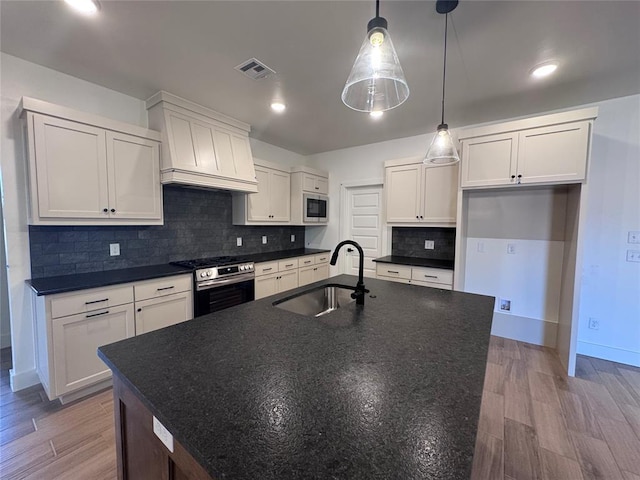6101 Kinnick Dr, Edmond, OK 73034 - kitchen featuring stainless steel range with gas stovetop, built in microwave, dark countertops, custom range hood, and white cabinets