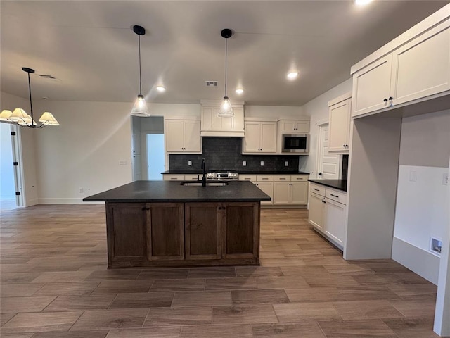 6101 Kinnick Dr, Edmond, OK 73034 - kitchen with dark countertops, built in microwave, backsplash, white cabinets, and recessed lighting