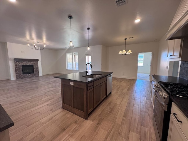 6101 Kinnick Dr, Edmond, OK 73034 - kitchen with a chandelier, stainless steel appliances, a stone fireplace, and open floor plan