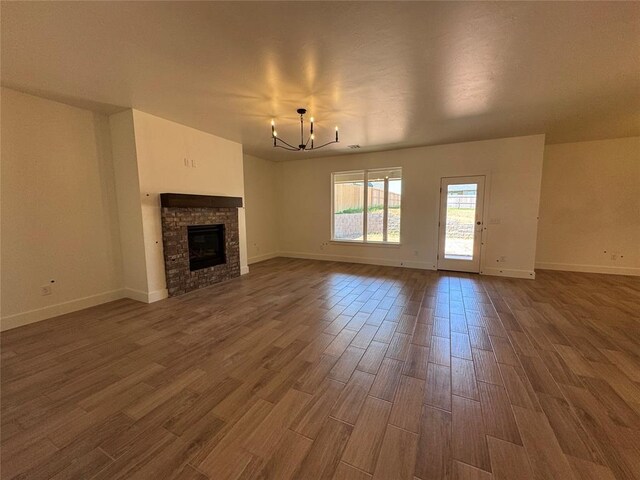 6101 Kinnick Dr, Edmond, OK 73034 - unfurnished living room featuring a chandelier, dark wood-type flooring, and a fireplace