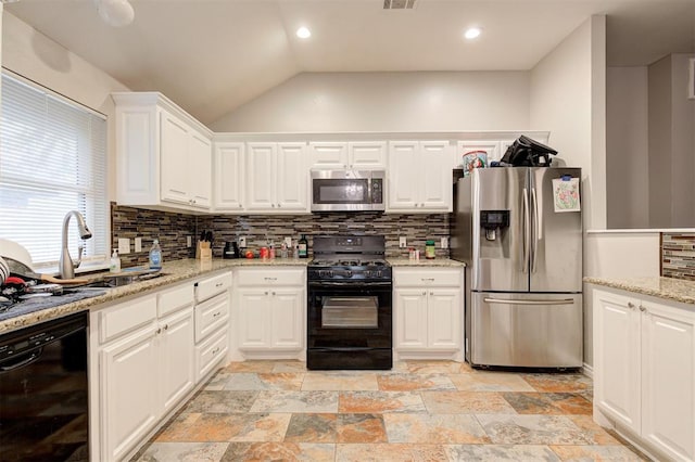 2732 SE 90th St, Moore, OK 73160 - kitchen featuring appliances with stainless steel finishes, backsplash, white cabinets, vaulted ceiling, and stone tile flooring