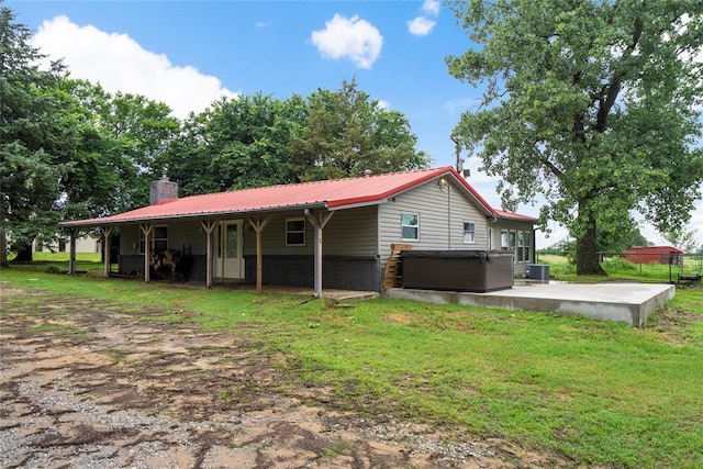 39525 W 151st St, Bristow, OK 74010 - back of house with a hot tub, a chimney, a patio, a metal roof, and a yard
