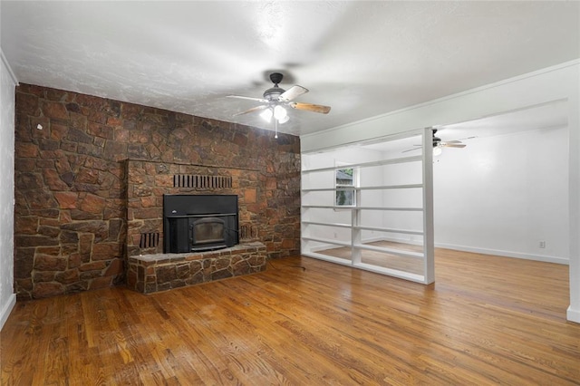 39525 W 151st St, Bristow, OK 74010 - unfurnished living room featuring ceiling fan, wood finished floors, a wood stove, and crown molding