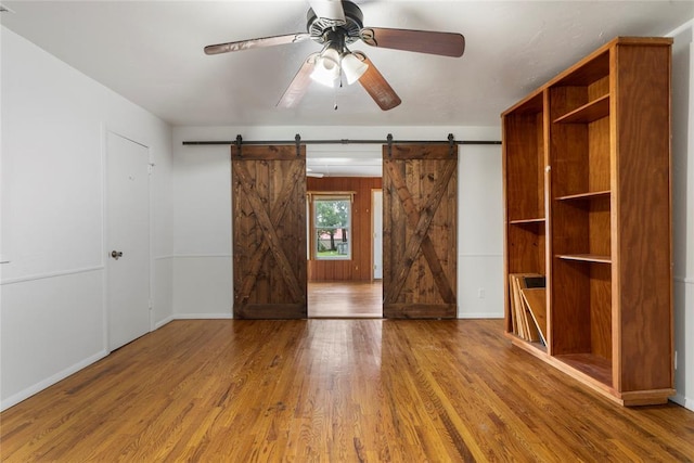 39525 W 151st St, Bristow, OK 74010 - unfurnished bedroom with a barn door and wood finished floors