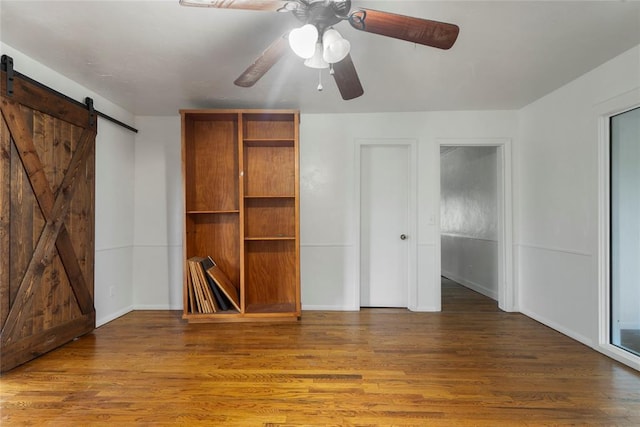 39525 W 151st St, Bristow, OK 74010 - unfurnished bedroom with a barn door, wood finished floors, and ceiling fan