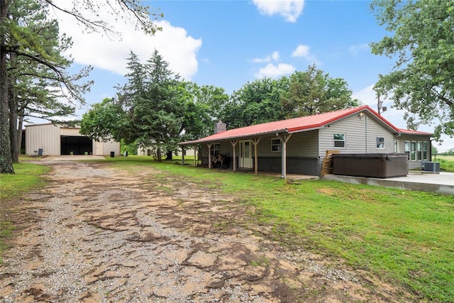 39525 W 151st St, Bristow, OK 74010 - back of property featuring a hot tub, a chimney, dirt driveway, a pole building, and an outdoor structure