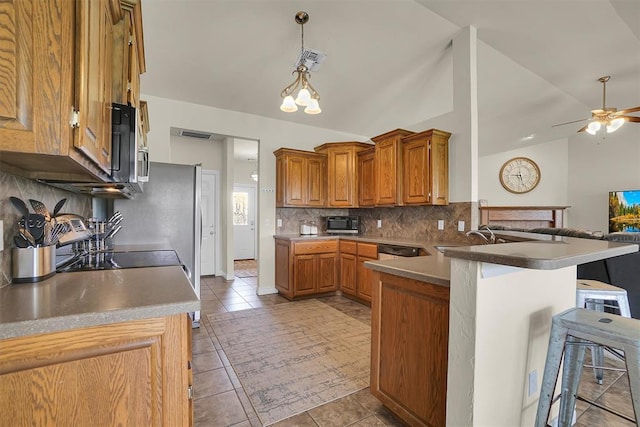 1809 Foxtail Cir, Altus, OK 73521 - kitchen featuring a peninsula, a breakfast bar, tasteful backsplash, brown cabinets, and vaulted ceiling