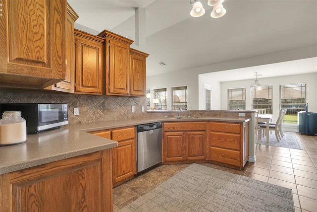 1809 Foxtail Cir, Altus, OK 73521 - kitchen featuring stainless steel appliances, a peninsula, a chandelier, brown cabinets, and vaulted ceiling