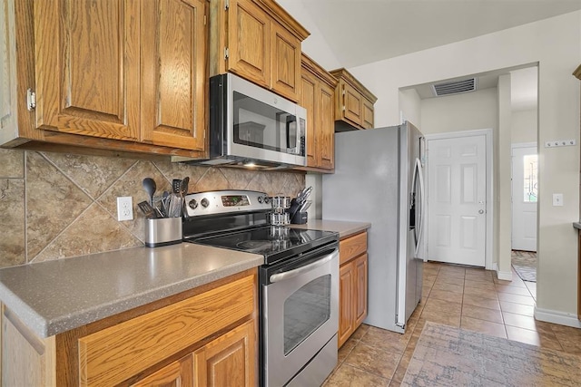 1809 Foxtail Cir, Altus, OK 73521 - kitchen with appliances with stainless steel finishes, brown cabinets, backsplash, and light tile patterned flooring