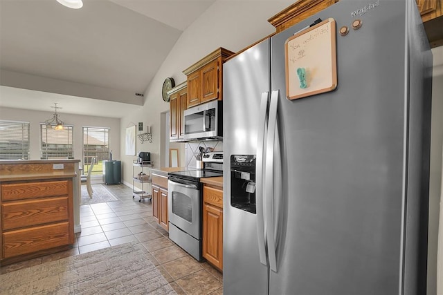 1809 Foxtail Cir, Altus, OK 73521 - kitchen featuring stainless steel appliances, vaulted ceiling, brown cabinets, light tile patterned floors, and light countertops