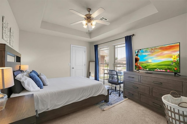 1809 Foxtail Cir, Altus, OK 73521 - bedroom featuring a tray ceiling, light carpet, and a ceiling fan