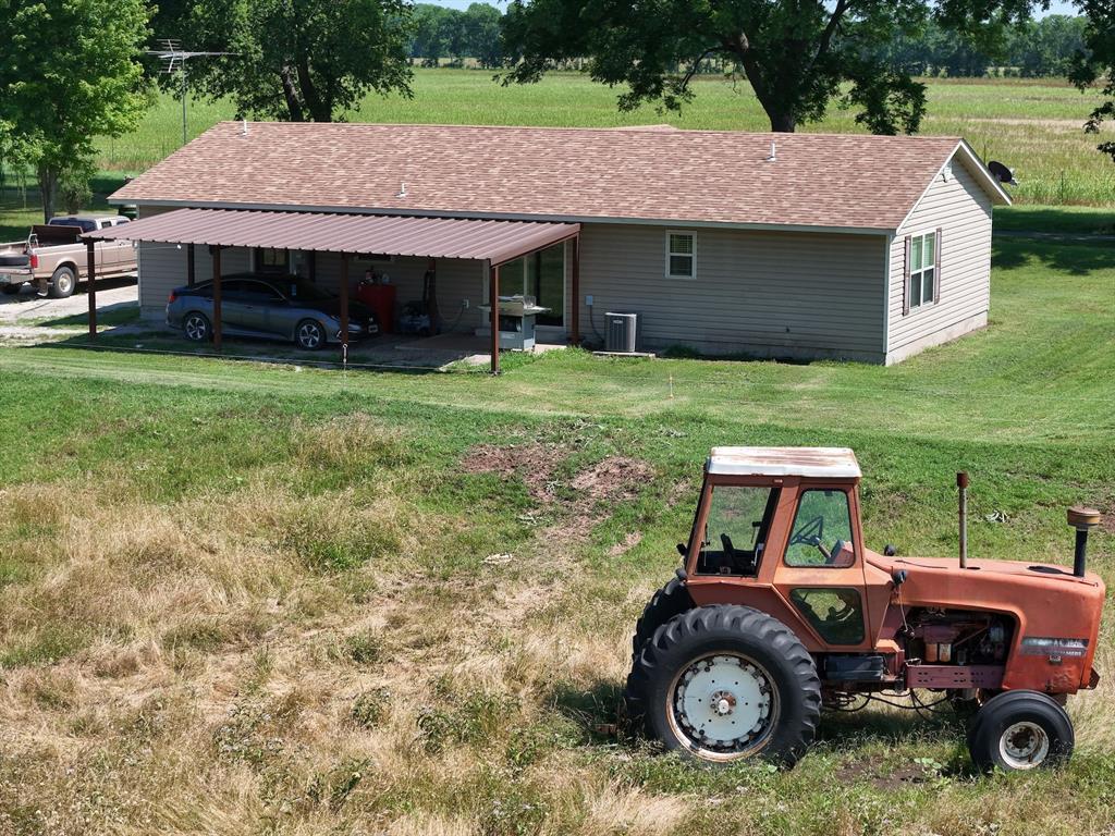 1103 Sooner Rock Rd, Davis, OK 73030 - rear view of property with roof with shingles, a yard, and a carport