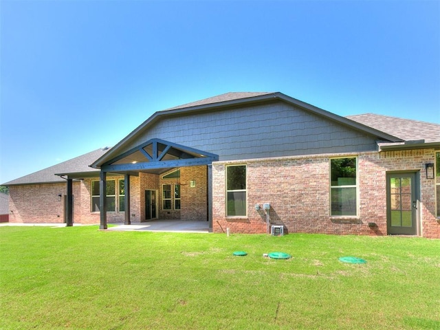 13524 SE 95th St, Oklahoma City, OK 73165 - rear view of property featuring a patio area, a lawn, and brick siding