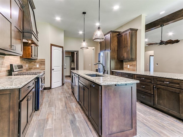 13524 SE 95th St, Oklahoma City, OK 73165 - kitchen featuring appliances with stainless steel finishes, a ceiling fan, a center island with sink, dark brown cabinetry, and decorative backsplash