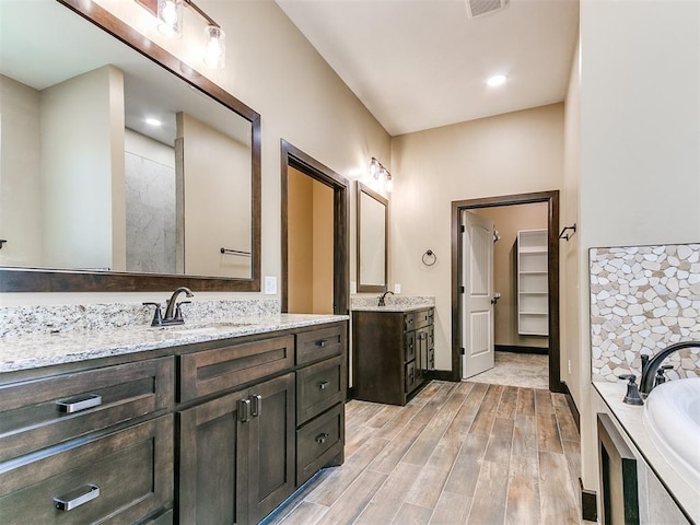 13524 SE 95th St, Oklahoma City, OK 73165 - bathroom with two vanities, a bath, wood finished floors, and a spacious closet