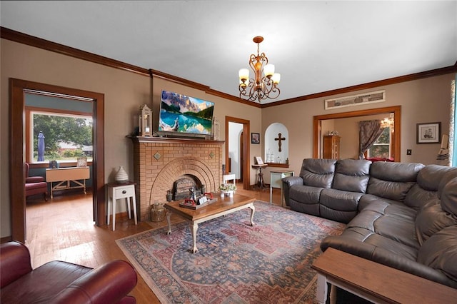 201 S Park Rd, Hobart, OK 73651 - living area with a chandelier, healthy amount of natural light, wood finished floors, ornamental molding, and a brick fireplace