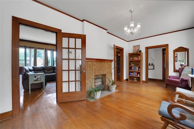 201 S Park Rd, Hobart, OK 73651 - living room featuring crown molding, wood finished floors, a brick fireplace, and a chandelier