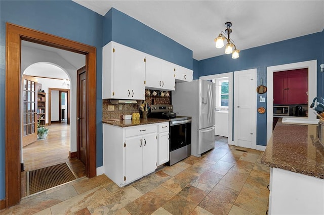 201 S Park Rd, Hobart, OK 73651 - kitchen with stainless steel appliances, stone tile flooring, backsplash, arched walkways, and white cabinetry