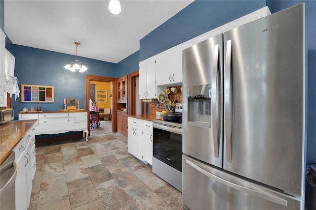 201 S Park Rd, Hobart, OK 73651 - kitchen featuring appliances with stainless steel finishes, tasteful backsplash, stone finish flooring, white cabinetry, and a chandelier