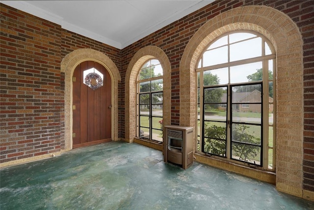 201 S Park Rd, Hobart, OK 73651 - foyer entrance with brick wall, unfinished concrete floors, and heating unit