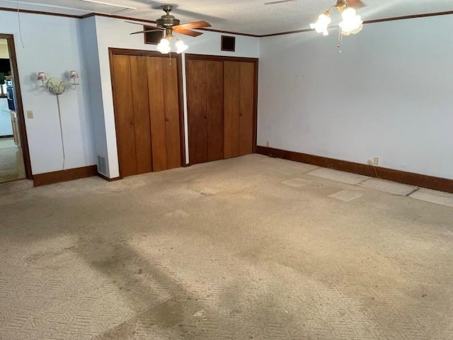 2 Sequoyah Blvd, Shawnee, OK 74801 - unfurnished bedroom featuring light colored carpet, two closets, ornamental molding, and a ceiling fan