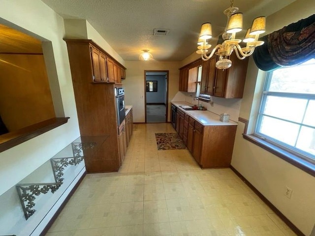 2 Sequoyah Blvd, Shawnee, OK 74801 - kitchen featuring a chandelier, light countertops, oven, brown cabinetry, and light flooring
