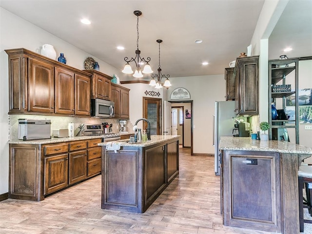 13512 SE 95th St, Oklahoma City, OK 73165 - kitchen featuring stainless steel appliances, an island with sink, backsplash, light wood-style floors, and recessed lighting