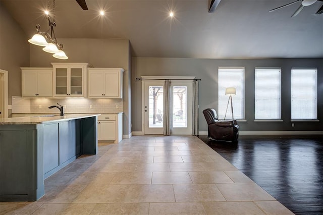 2329 Chase Way, Yukon, OK 73099 - kitchen with open floor plan, tasteful backsplash, white cabinets, glass insert cabinets, and lofted ceiling