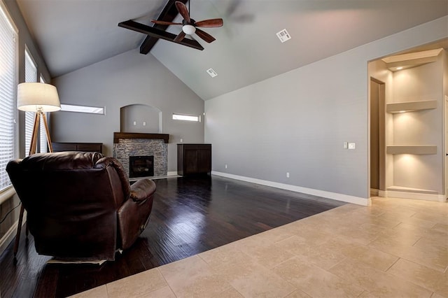 2329 Chase Way, Yukon, OK 73099 - tiled living room with ceiling fan, a stone fireplace, beam ceiling, and high vaulted ceiling