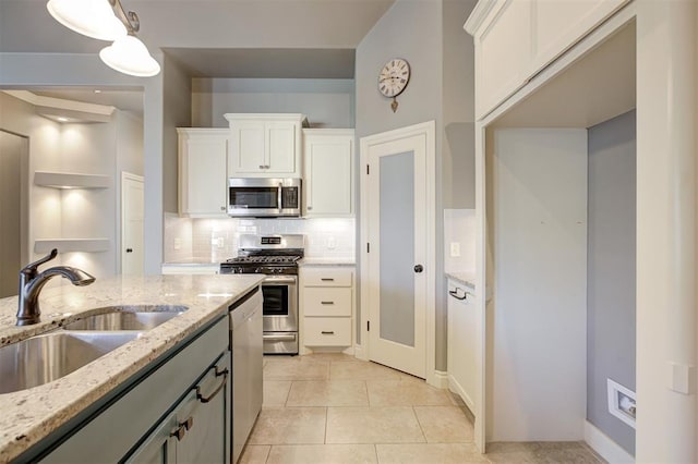 2329 Chase Way, Yukon, OK 73099 - kitchen with appliances with stainless steel finishes, backsplash, white cabinetry, light tile patterned floors, and light stone countertops