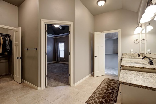 2329 Chase Way, Yukon, OK 73099 - bathroom with a spacious closet, double vanity, tile patterned flooring, and lofted ceiling