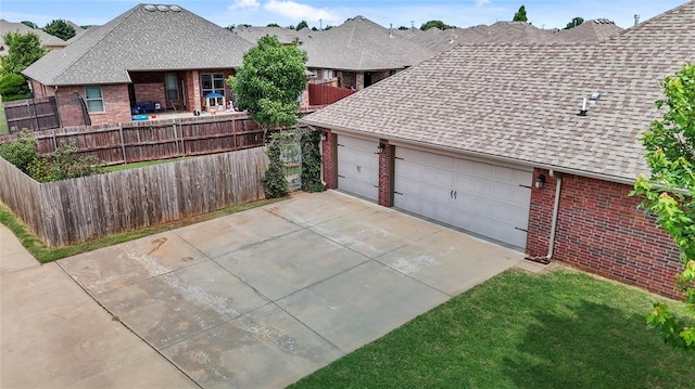 2329 Chase Way, Yukon, OK 73099 - view of home's exterior featuring brick siding, a shingled roof, driveway, and an attached garage