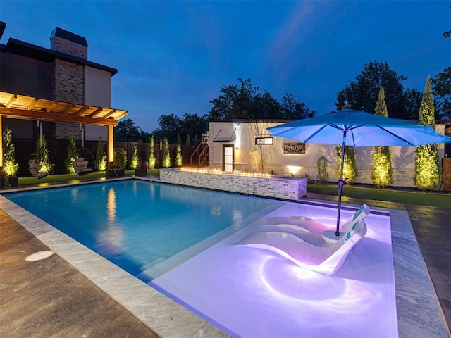 2824 Guilford Ln, Oklahoma City, OK 73120 - pool at night featuring a fenced backyard and a jacuzzi