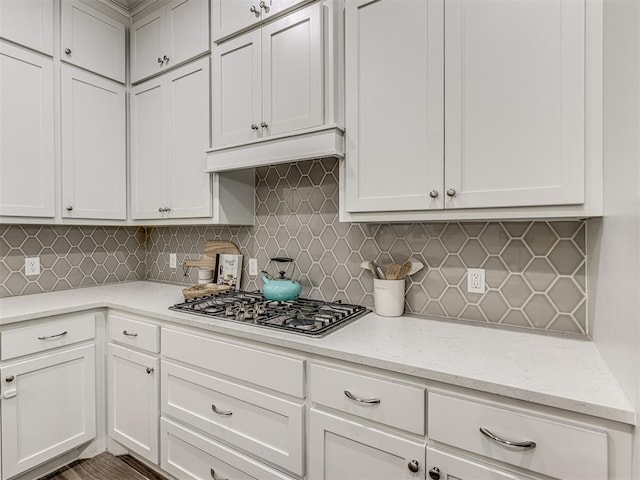 11104 Fairways Ave, Yukon, OK 73099 - kitchen featuring stainless steel gas stovetop, decorative backsplash, light stone counters, and white cabinetry