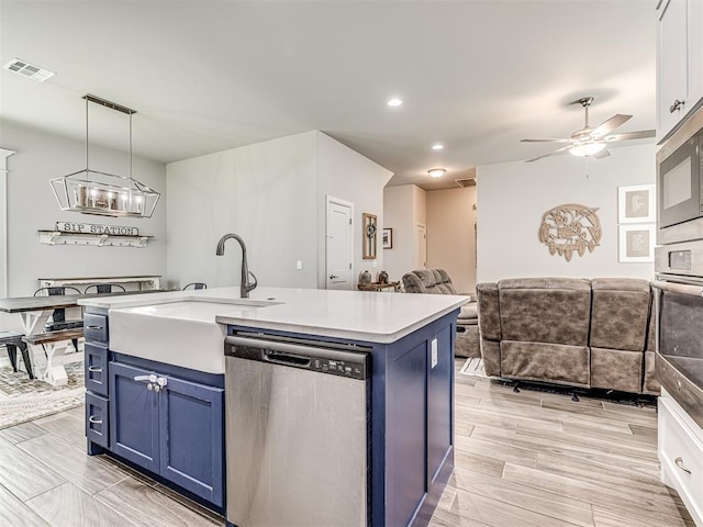 11104 Fairways Ave, Yukon, OK 73099 - kitchen featuring appliances with stainless steel finishes, blue cabinets, light countertops, ceiling fan, and open floor plan
