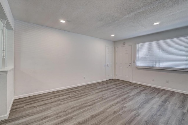 1409 Mcdonald Dr, Midwest City, OK 73130 - spare room with a textured ceiling, wood finished floors, and recessed lighting