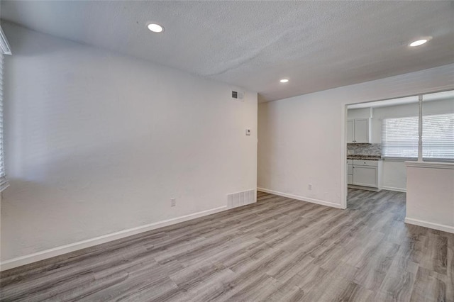 1409 Mcdonald Dr, Midwest City, OK 73130 - unfurnished room featuring wood finished floors, a textured ceiling, and recessed lighting